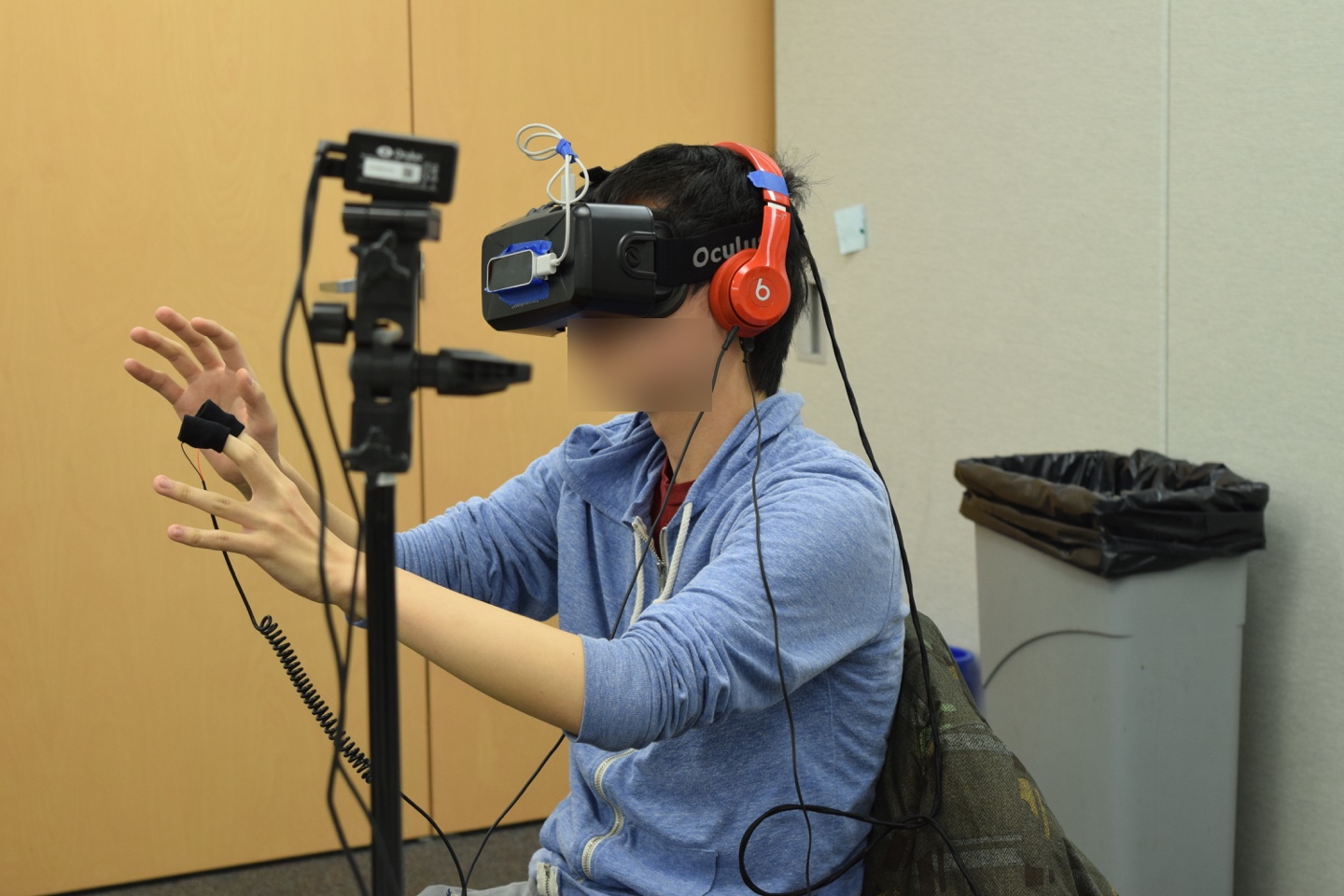 On this subject, you can see the abundance of the required technology: the Oculus DK2 on his face with the positional tracker on a tripod, headphones for sound, the Leap Motion on the Oculus DK2 to track his hands, a skin conductance monitor on his fingers, and a heart rate monitor on his ear.
